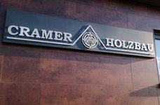 Firmenwerbung Cramer Holzbau Geseke – Edelstahlschrift u. -Logo mit Abstand auf anthrazitfarbenen Grundkörper gesetzt, mit LED-Hinterleuchtung