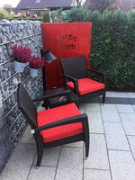 Geschmackvolle Sitzecke, farblich perfekt abgestimmt mit rot beschichteter Motivwand „Carpe Diem“