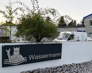 Heizungs- und Sanitärbau „Wassermann“ - Edelstahlschrift u. -Logo mit Abstand auf anthrazitfarbenen Grundkörper gesetzt, mit LED-Hinterleuchtung